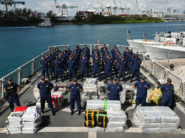 The crew members from Coast Guard Cutter Venturous pose before preparing to offload a pallet of illegal narcotics at Coast Guard Base Miami Beach, May 2, 2025. The seized contraband was the result of four interdictions in the Caribbean Sea by the crews of USCGC Diligence (WMEC-616) and HNLMS Groningen (P843) with an embarked Coast Guard law enforcement detachment. (U.S. Coast Guard photo by Petty Officer 3rd Class Jessica Walker)