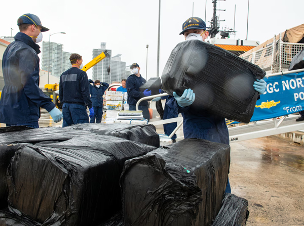 Crew members of USCGC Northland (WMEC 904) stack bales of illicit drugs on pallets during a drug offload at U.S. Coast Guard Base Miami Beach, July 2, 2025.